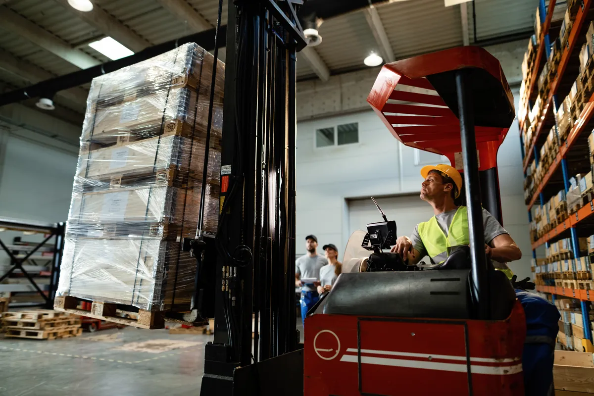 Forklift operator loading cargo in a logistics warehouse