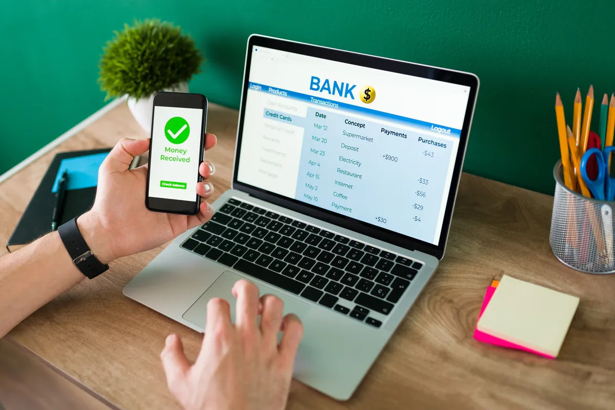 Customer using a mobile banking app on smartphone and laptop