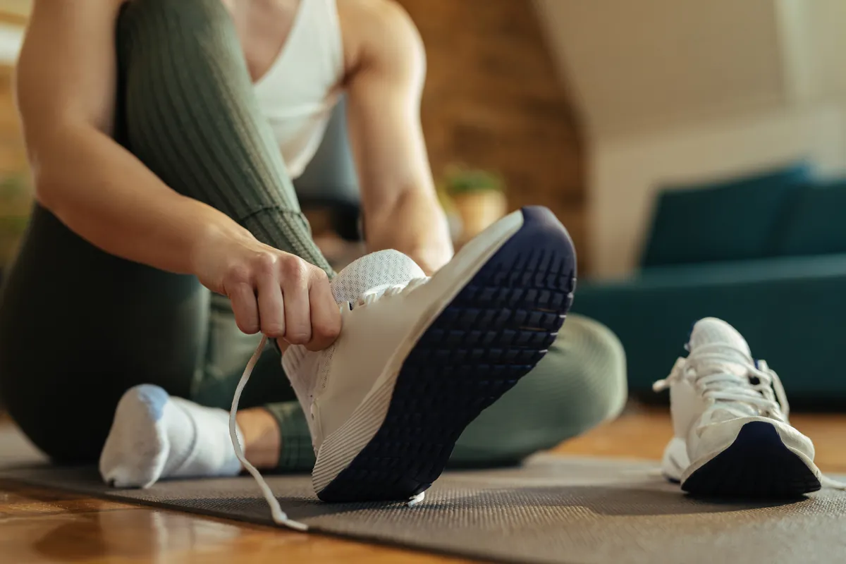 Runner lacing up running shoes